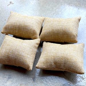 Four tan jute look miniature pillows. 3 inch by 2 inches rectangles.
